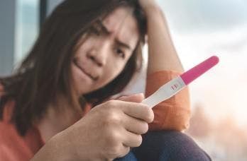 teen looking at pregnancy test