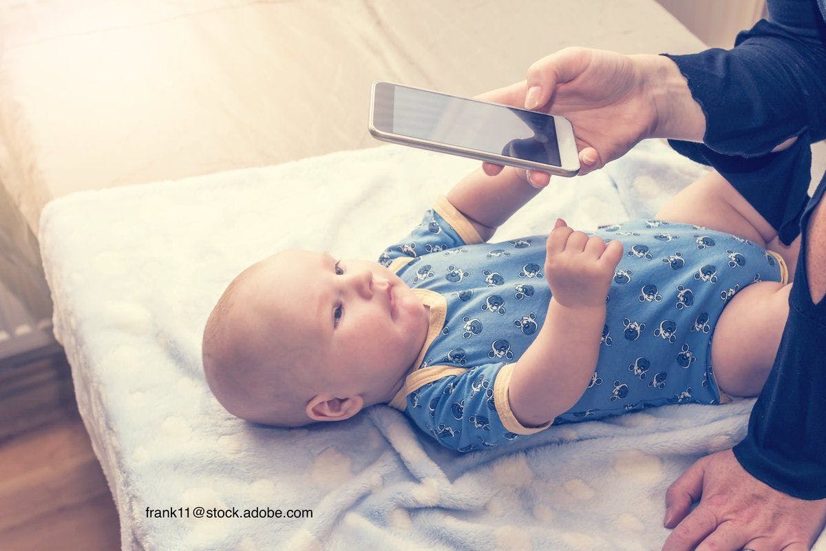 baby having picture taken on a cell phone