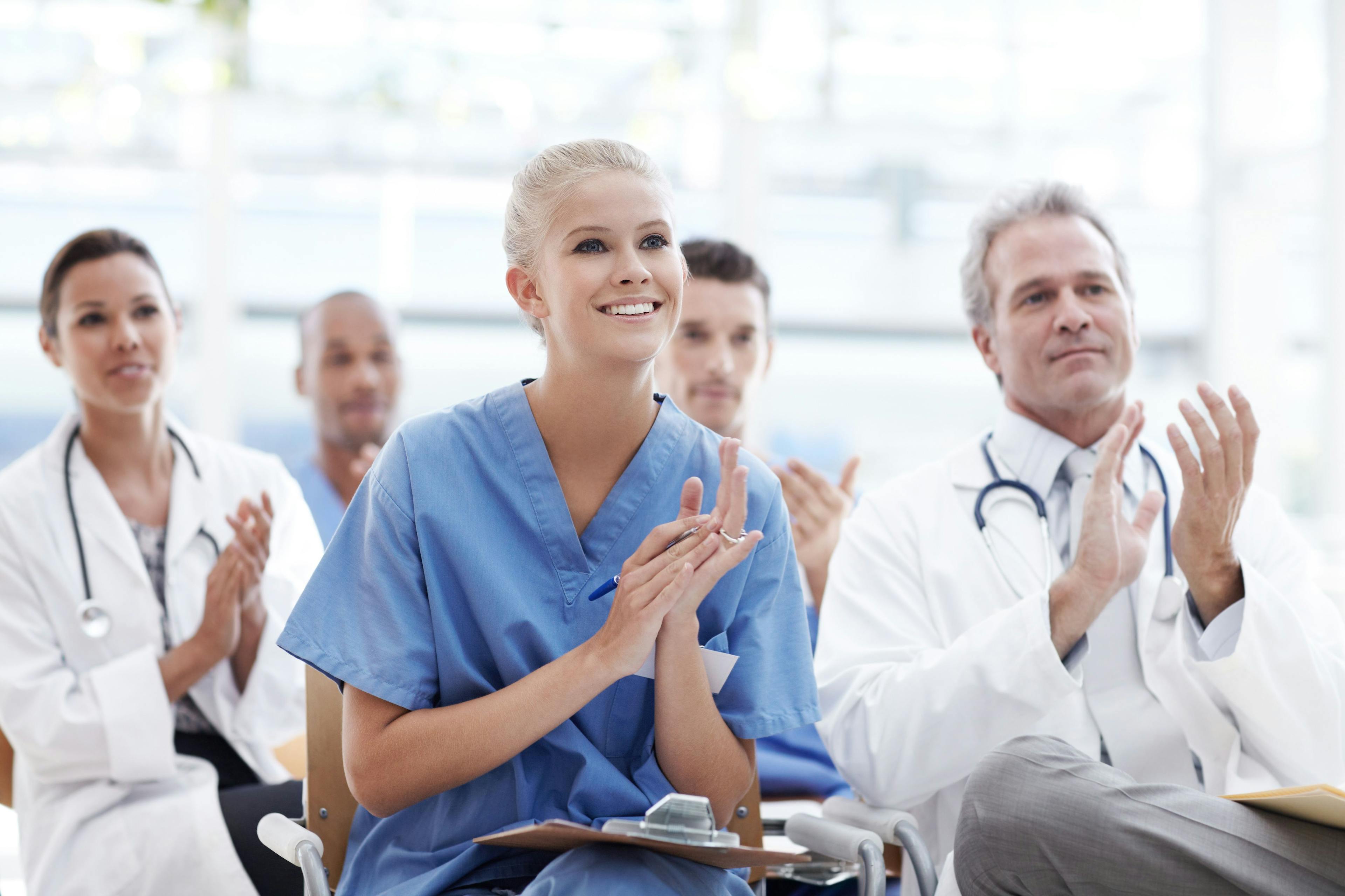 Celebrating breakthroughs in health care. Doctors and nurses applauding their lecturer: © Stigur/peopleimages.com - stock.adobe.com