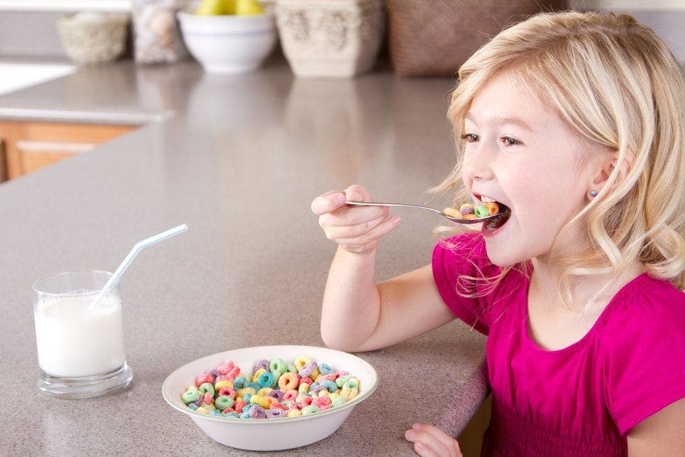 stock image of girl eating sugary cereal