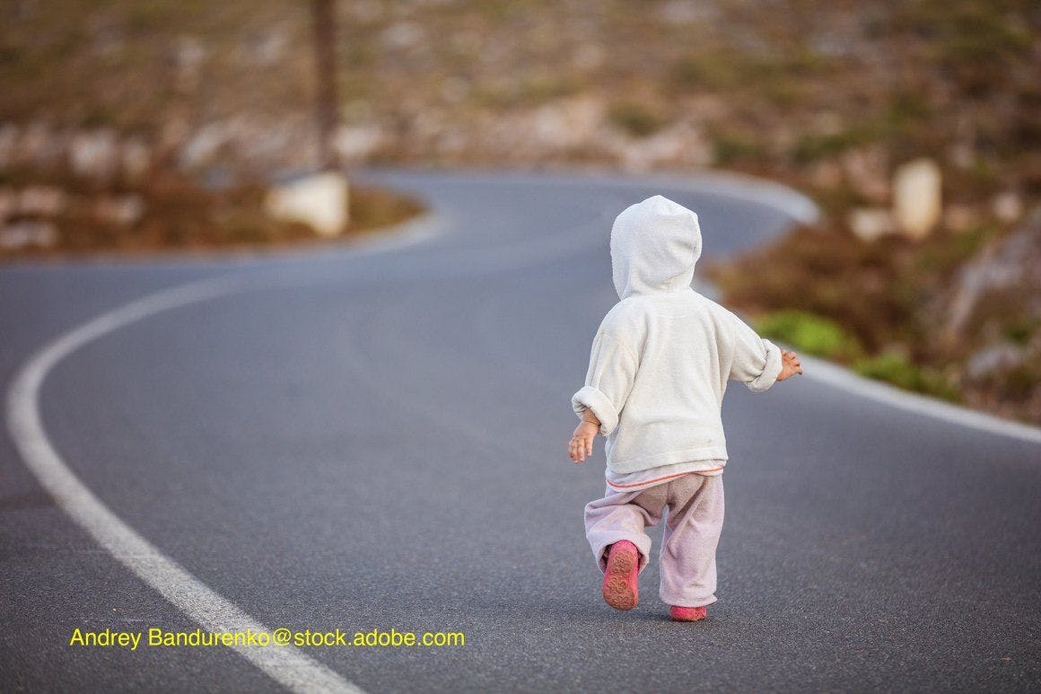 image of child wandering on road