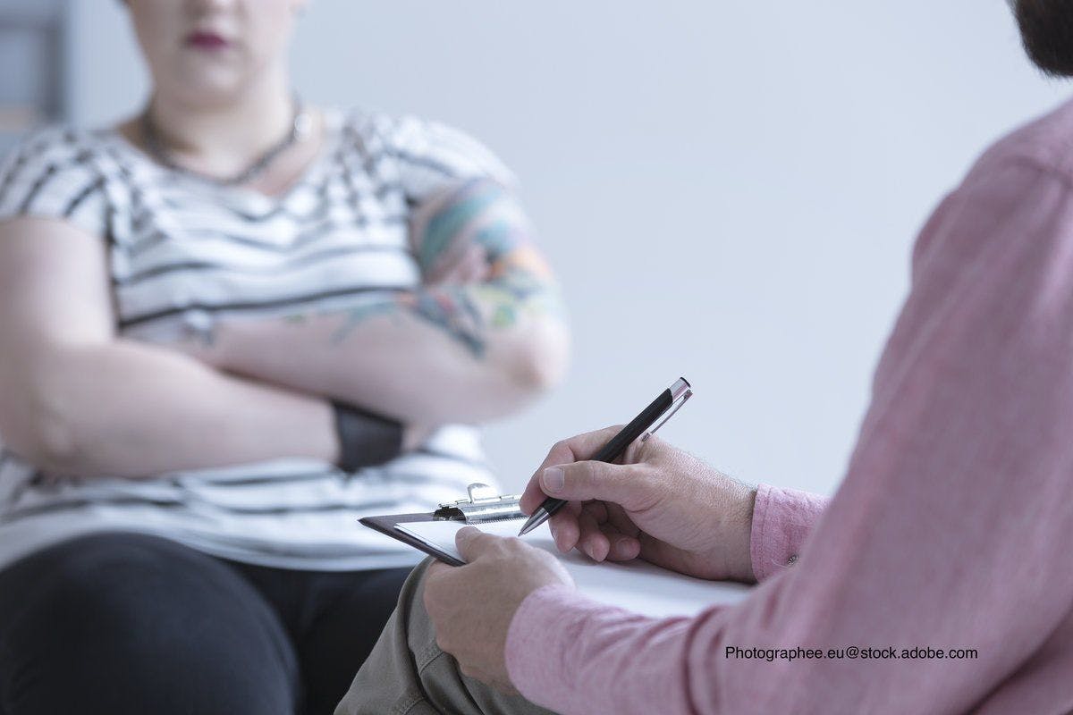 overweight teen speaking to mental health professional