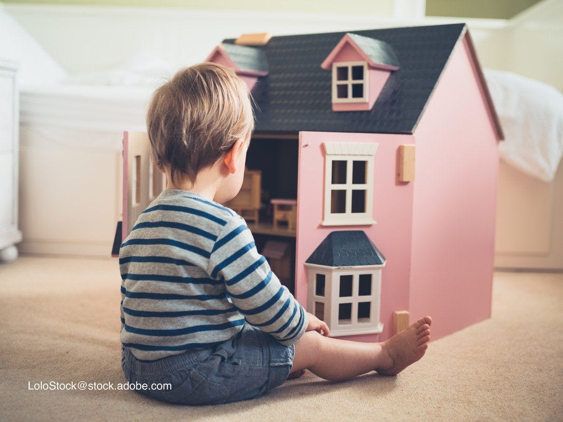 boy playing with a dollhouse