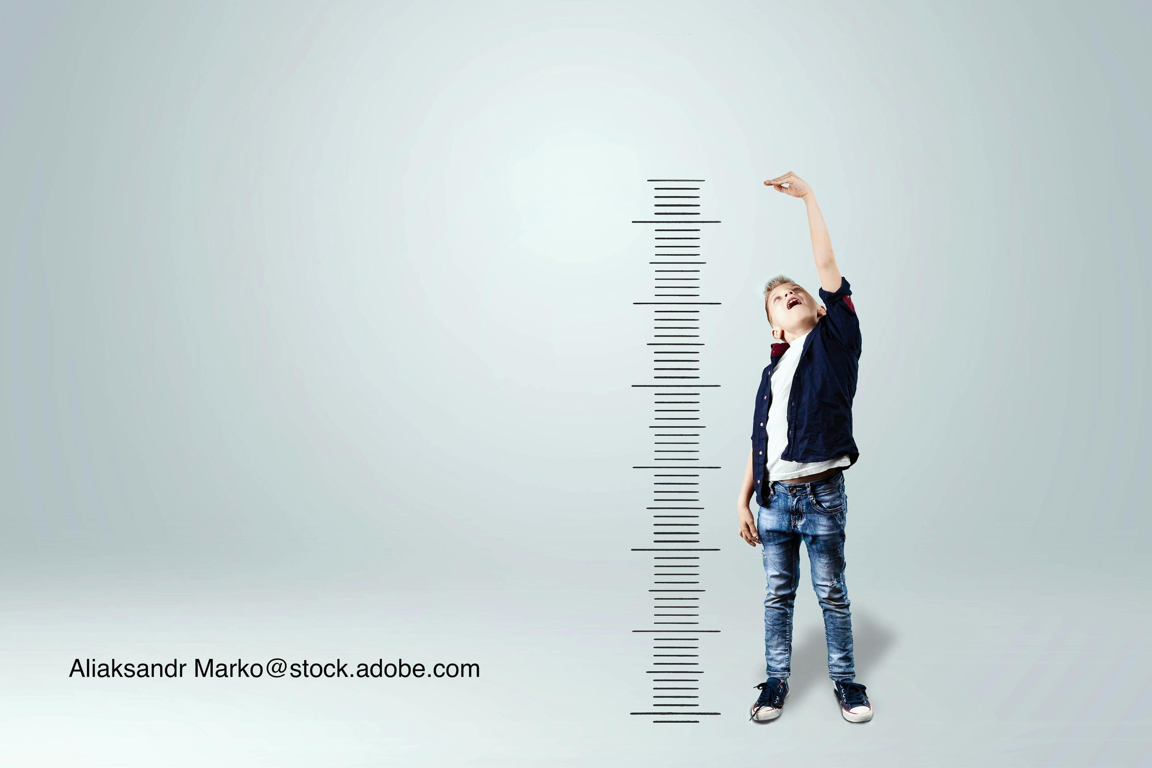 image of boy looking at a height chart